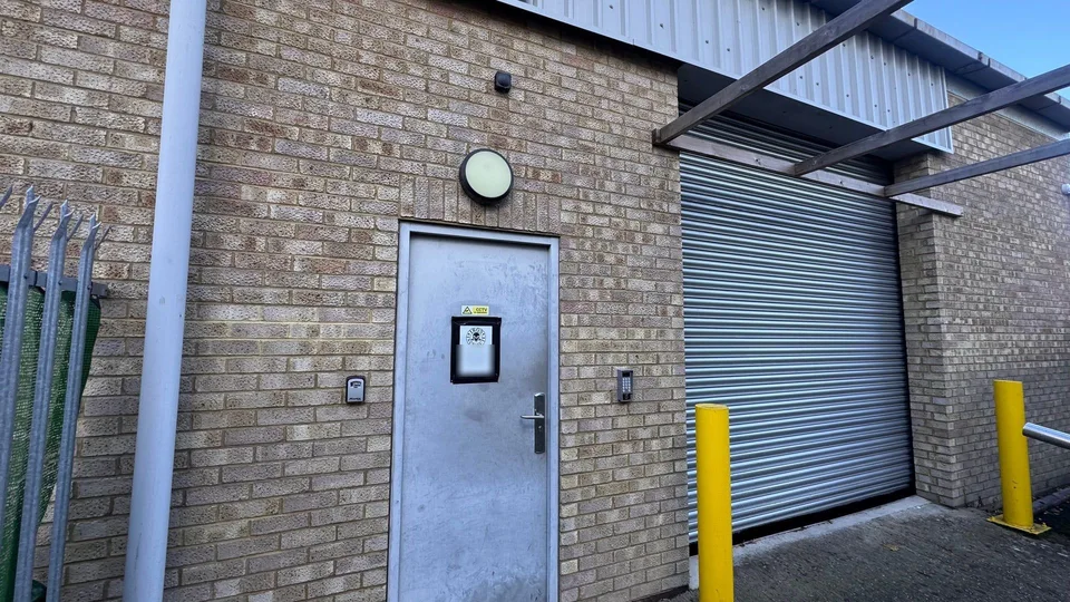 The front door of Iron Institute on Hollands Road, Haverhill, with a CCTV sign and the access reader beside it