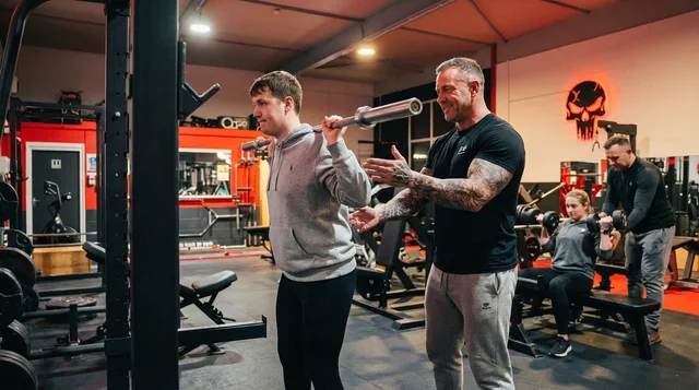 Beginner being coached on proper form at Iron Institute